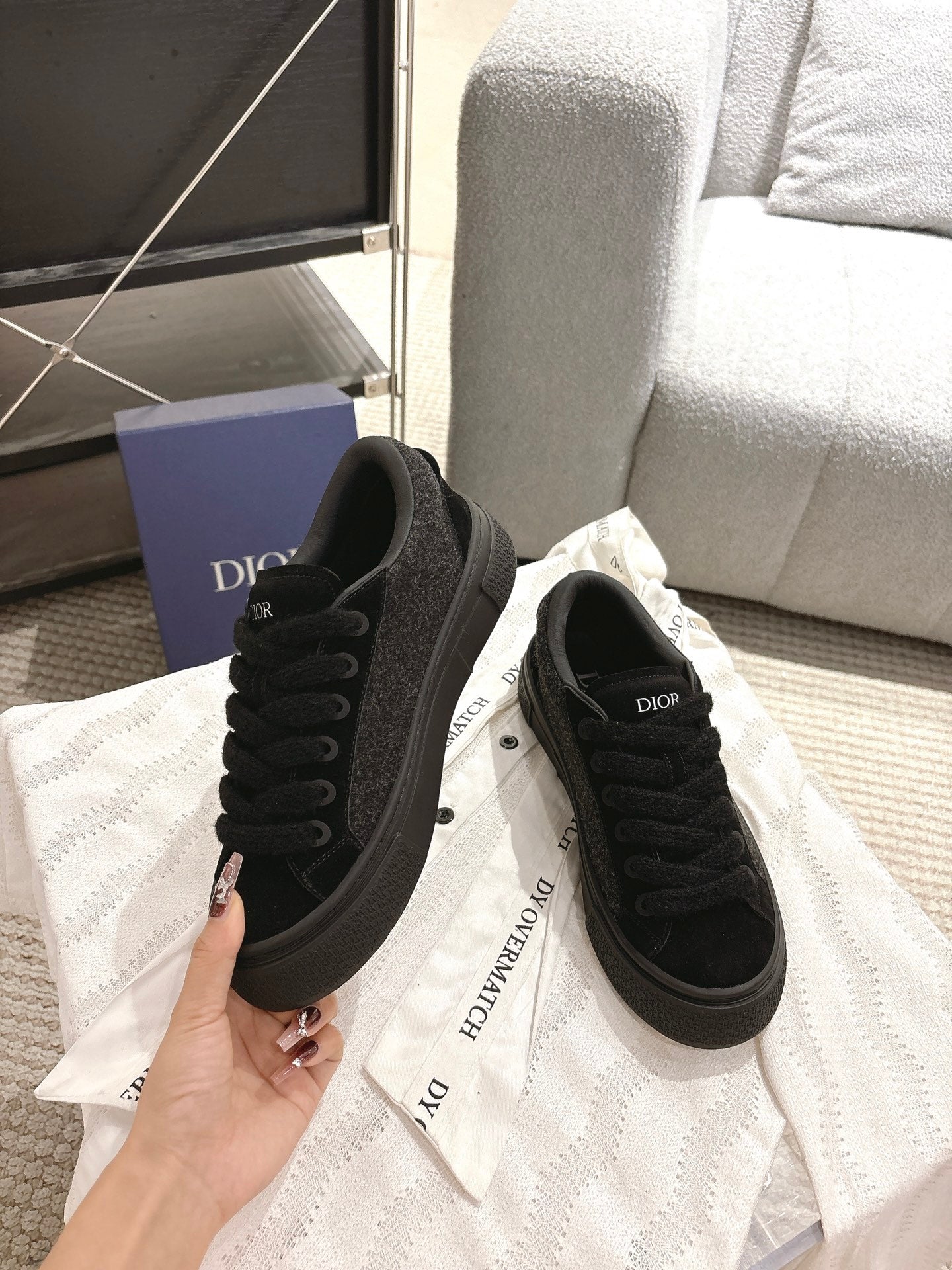 Black Dior lace-up sneakers, front and side angles showing stitched details