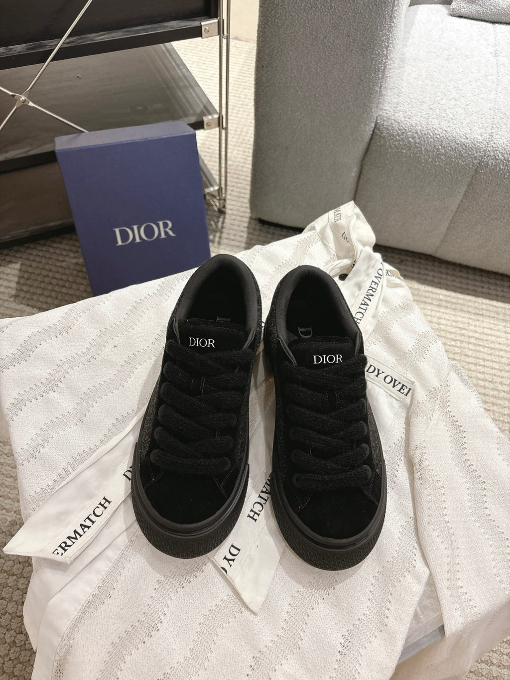 Black Dior lace-up sneakers with textured upper, low profile sole and rubber toe cap
