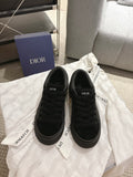 Black Dior lace-up sneakers with textured upper, low profile sole and rubber toe cap