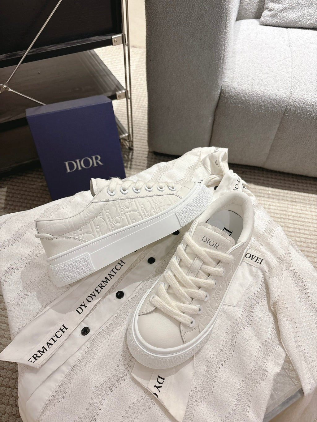 White Dior sneakers angled side view, lace-up closure with chunky rubber sole