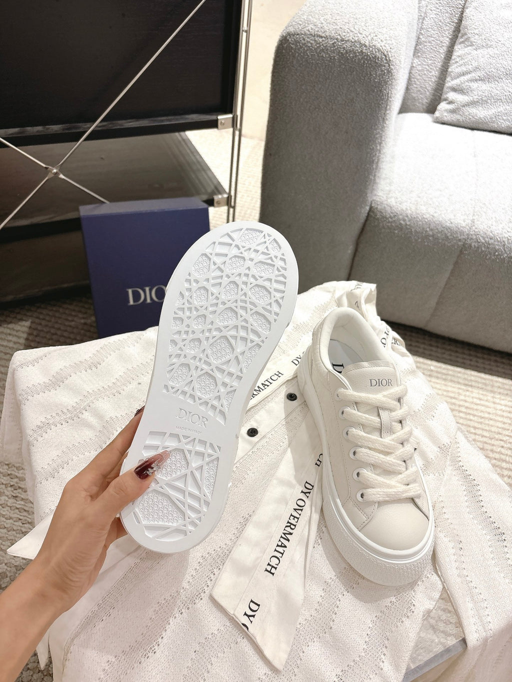 White Dior sneakers bottom view, textured outsole with tread pattern