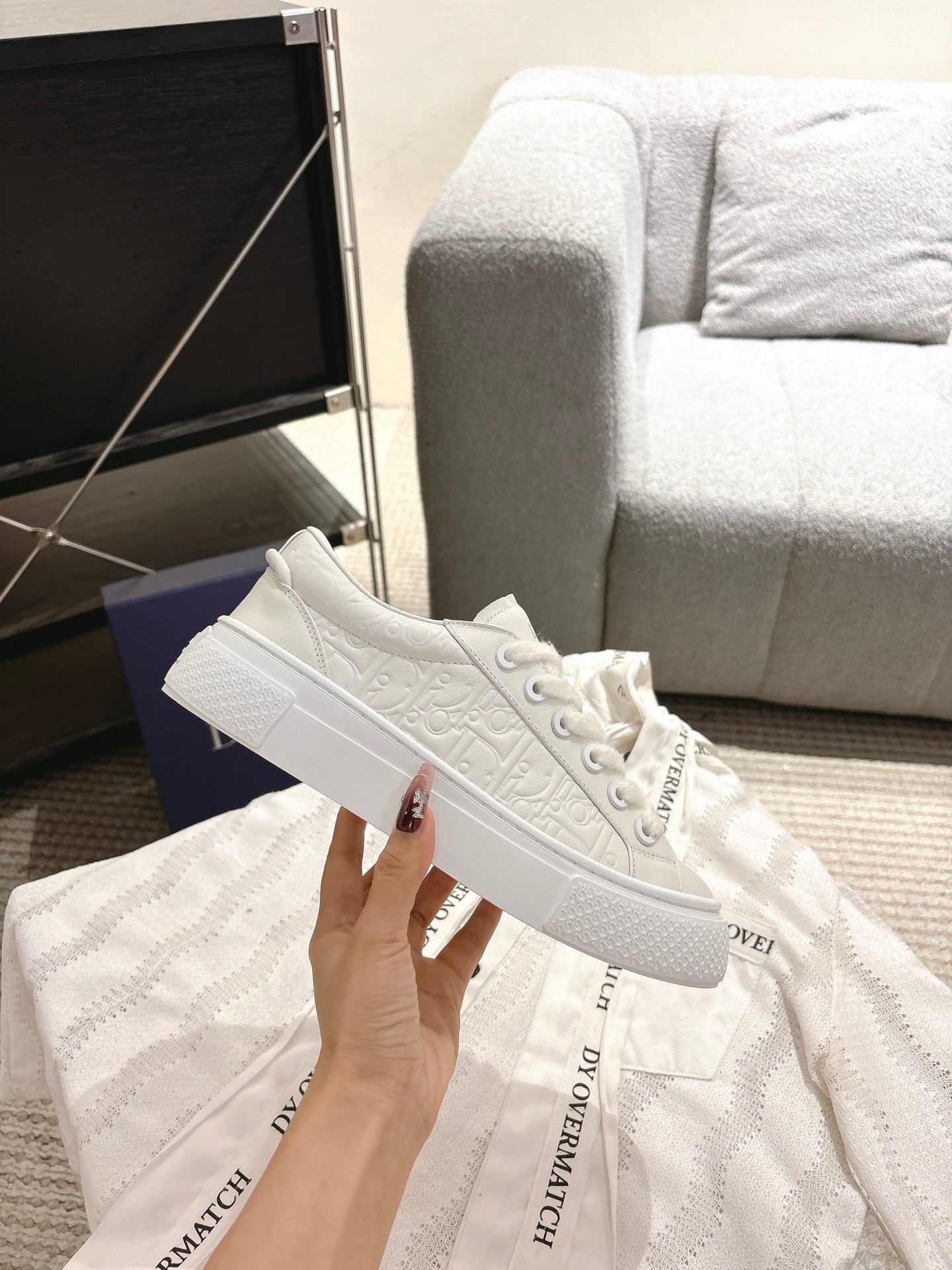 White Dior sneakers side profile with rubber toe cap and textured upper