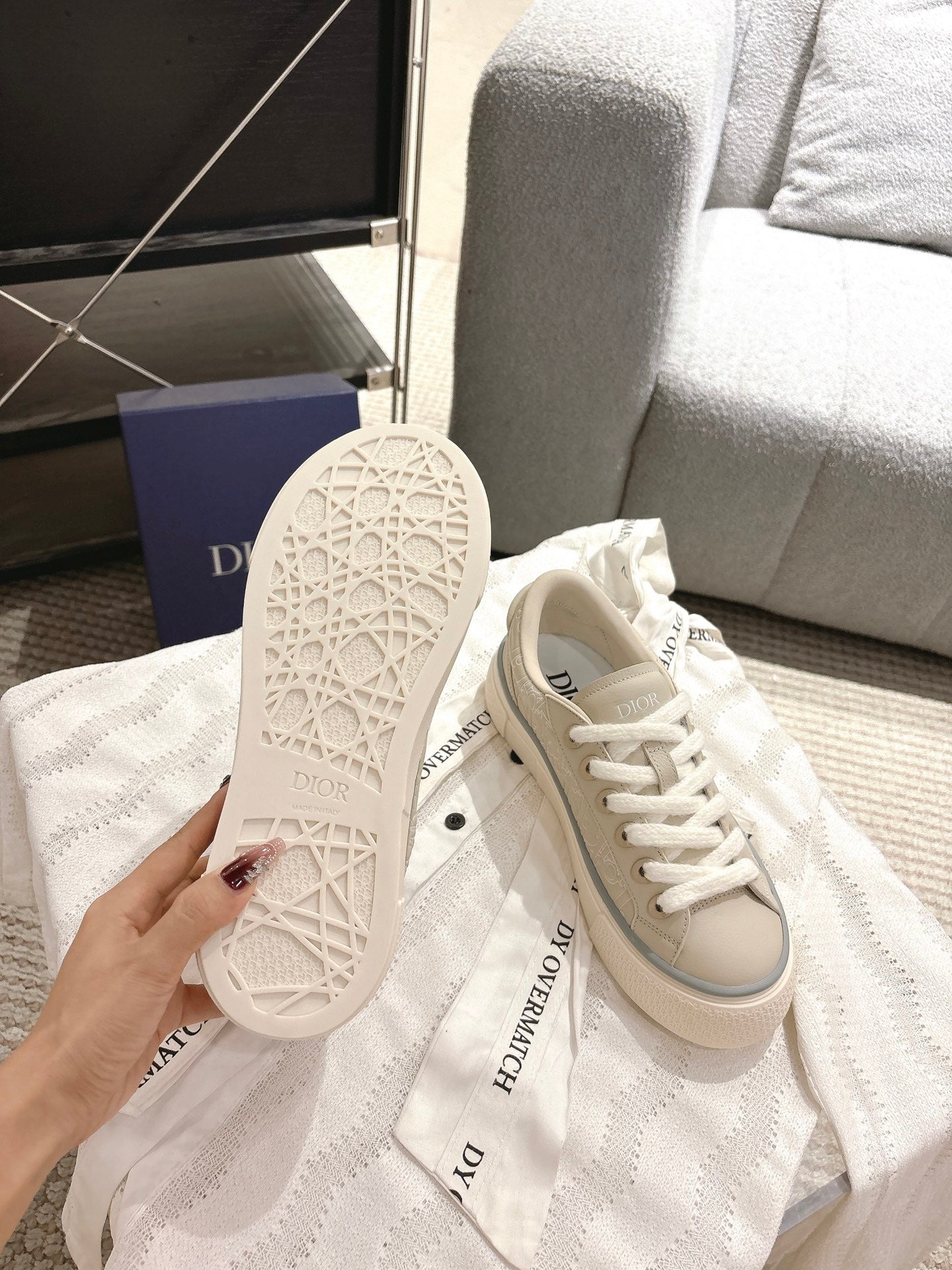 Light beige sneaker outsole with geometric tread pattern and side panel view
