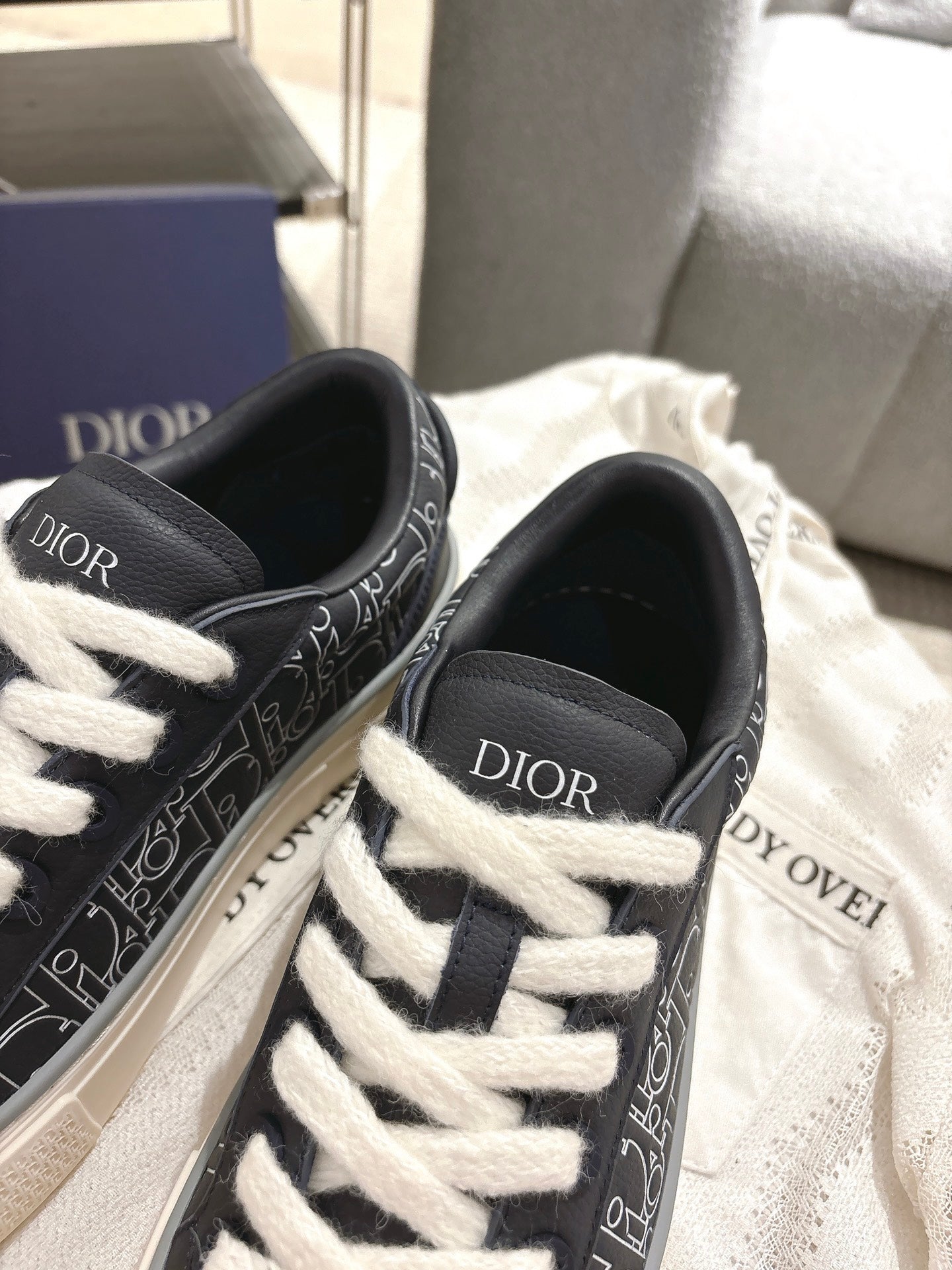 Dior unisex sneakers, close-up of black uppers with white laces and Dior branding