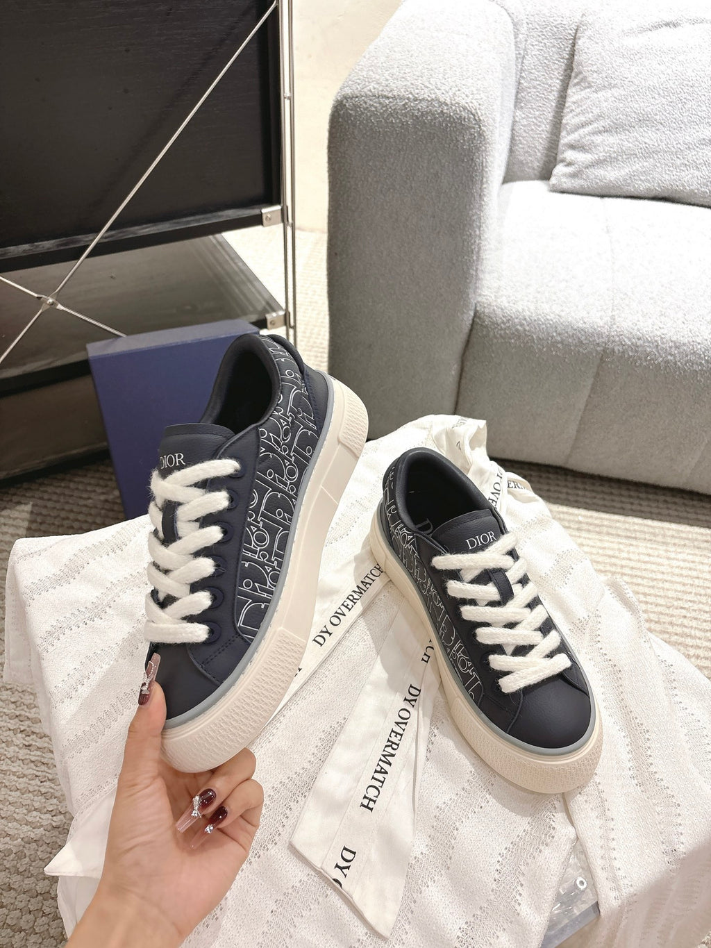 Dior unisex sneakers held up, navy patterned sides with white laces and rubber sole