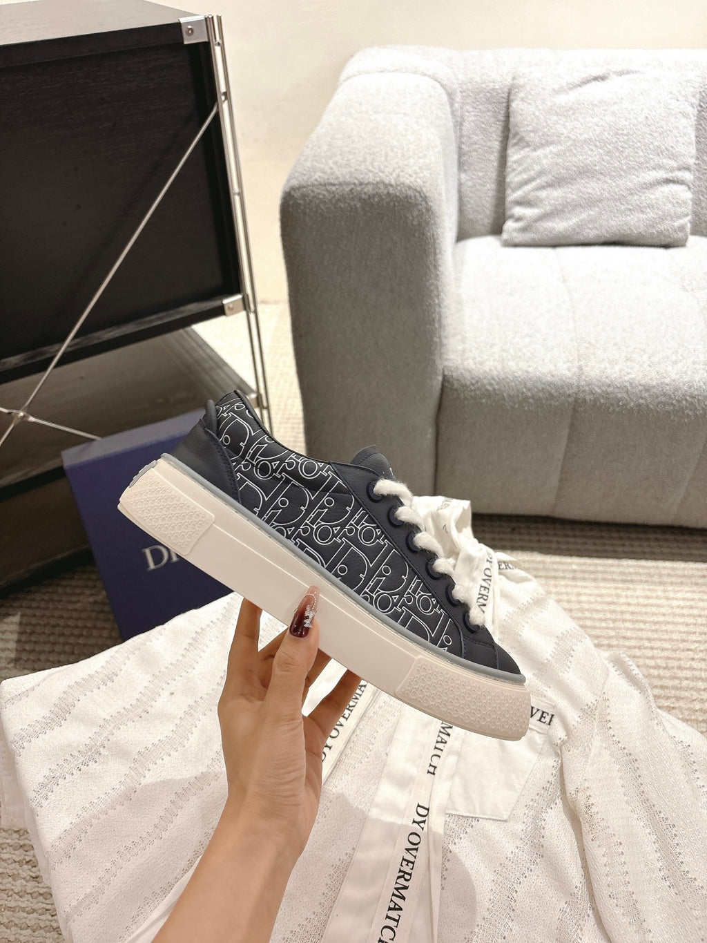 Dior unisex sneakers side view, navy patterned upper with white laces and thick sole