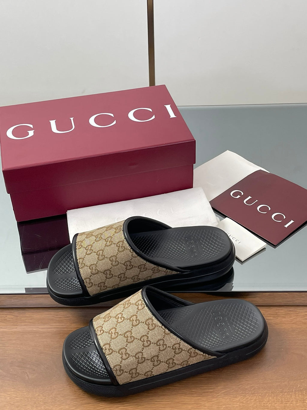 Gucci slide sandals with beige GG canvas cross straps and black rubber footbeds