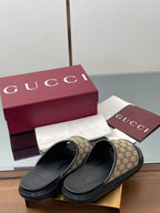 Gucci slide sandals with beige GG canvas straps and black rubber slide soles
