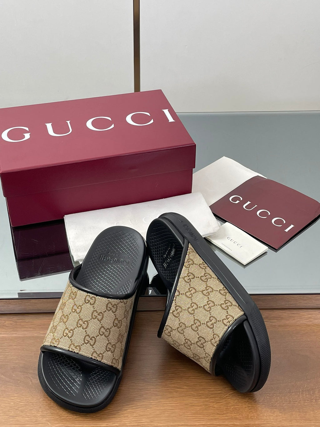 Gucci slide sandals with black top straps and beige GG canvas panels