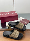 Gucci slide sandals with beige GG canvas straps and black rubber footbeds