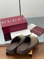 Gucci slide sandals with tan GG monogram uppers and dark rubber footbeds