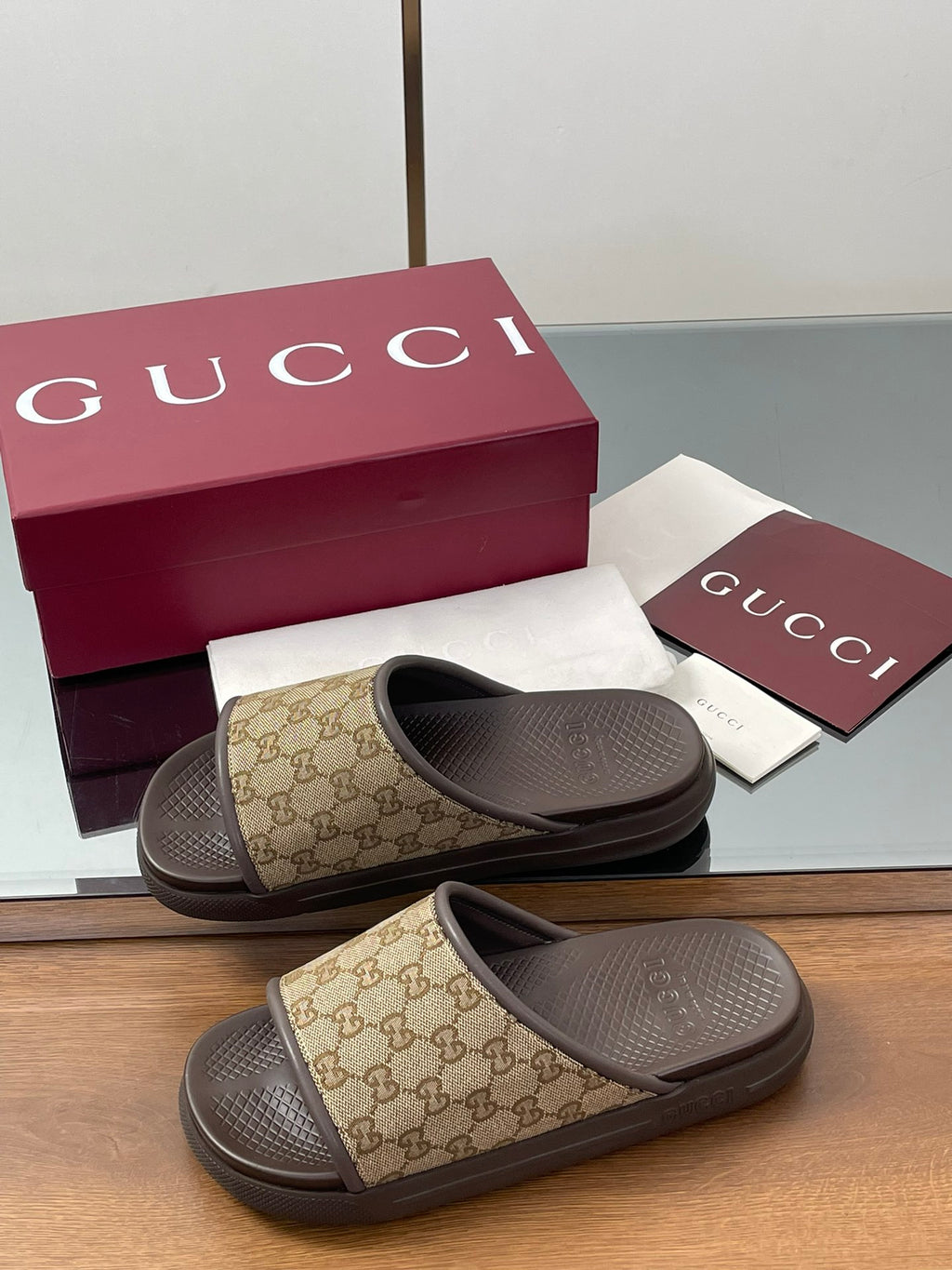 Gucci slide sandals in tan GG canvas with dark rubber sole and cushioned footbed
