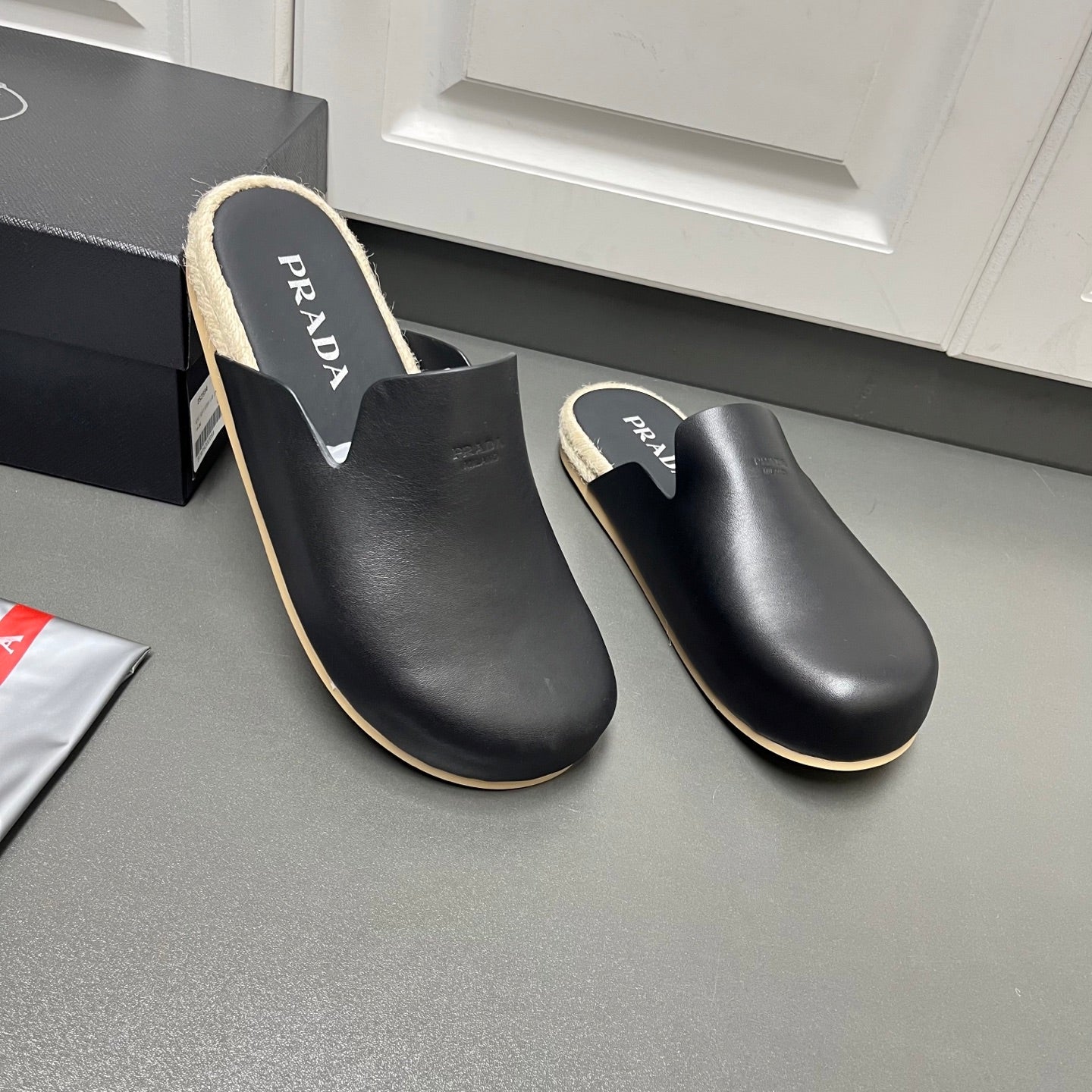 Prada black leather slide sandals with PRADA branding on insole and shearling collar