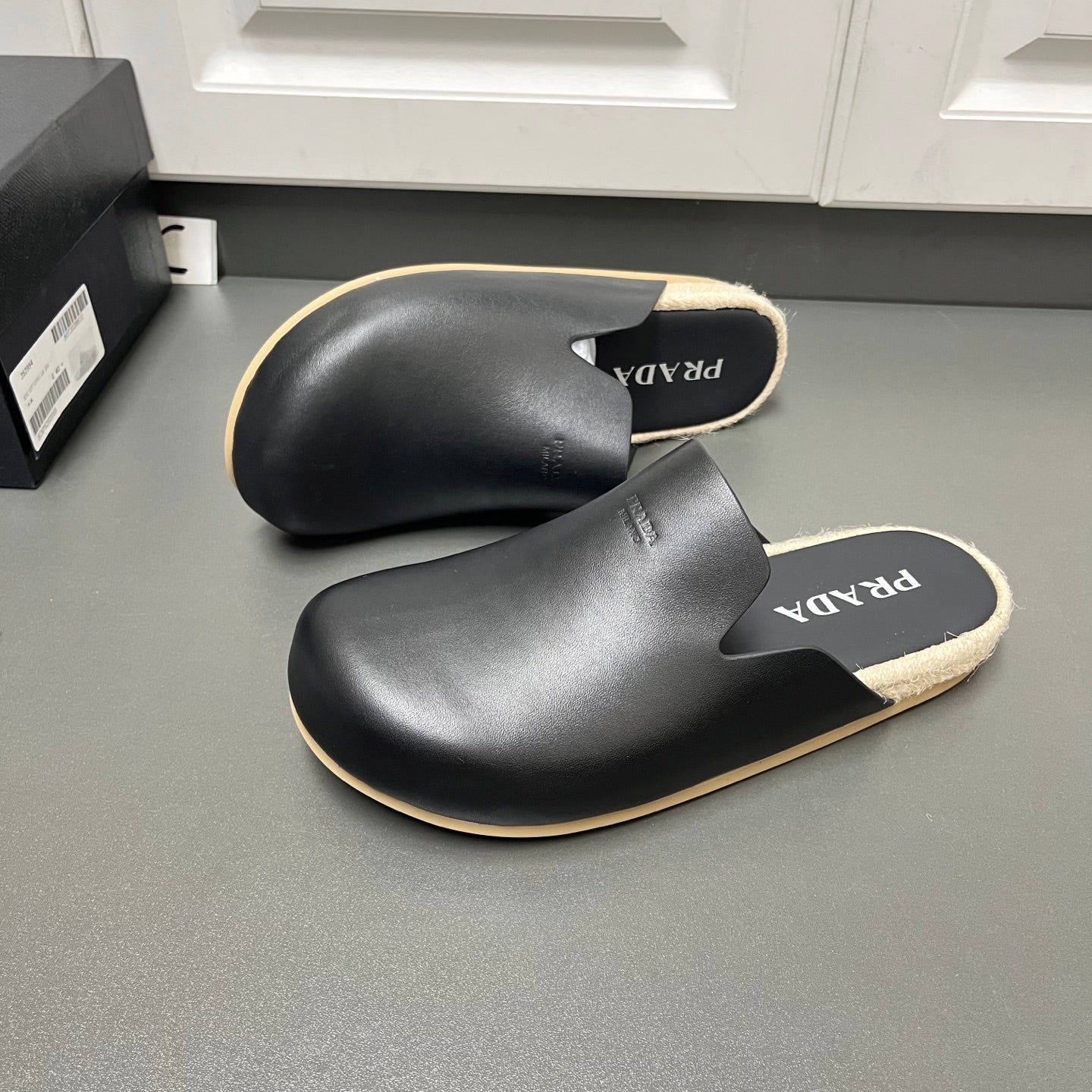 Prada black slide sandals with cutout upper, beige trim, jute-style sole edge