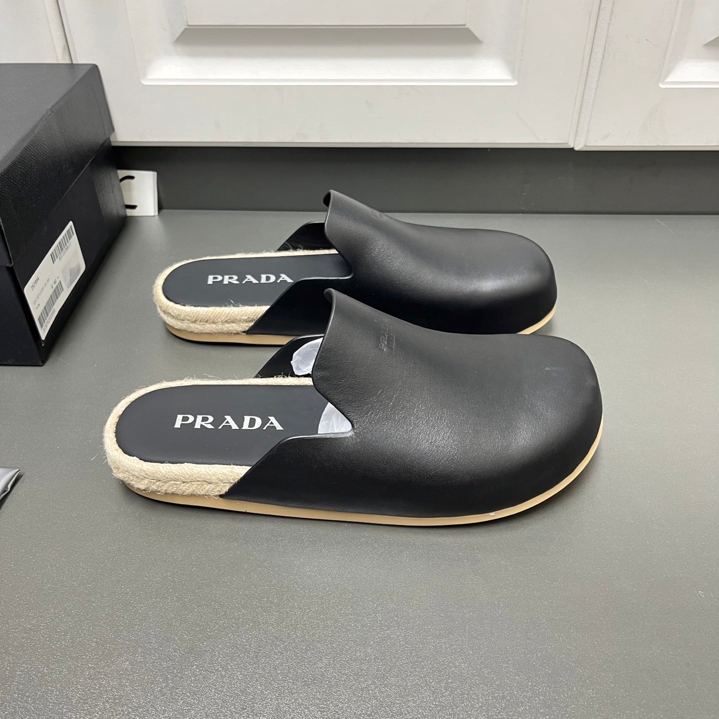 Prada black slide sandals with PRADA logo footbeds and beige shearling trim