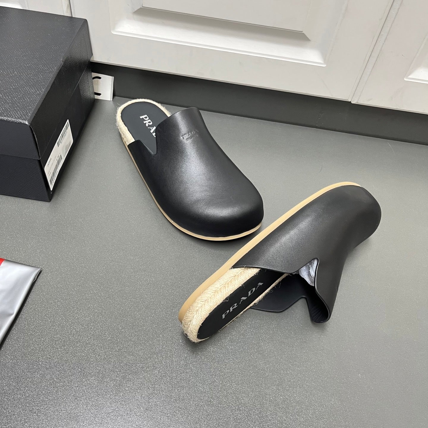 Prada black slide sandals showing heel opening and beige lined footbed