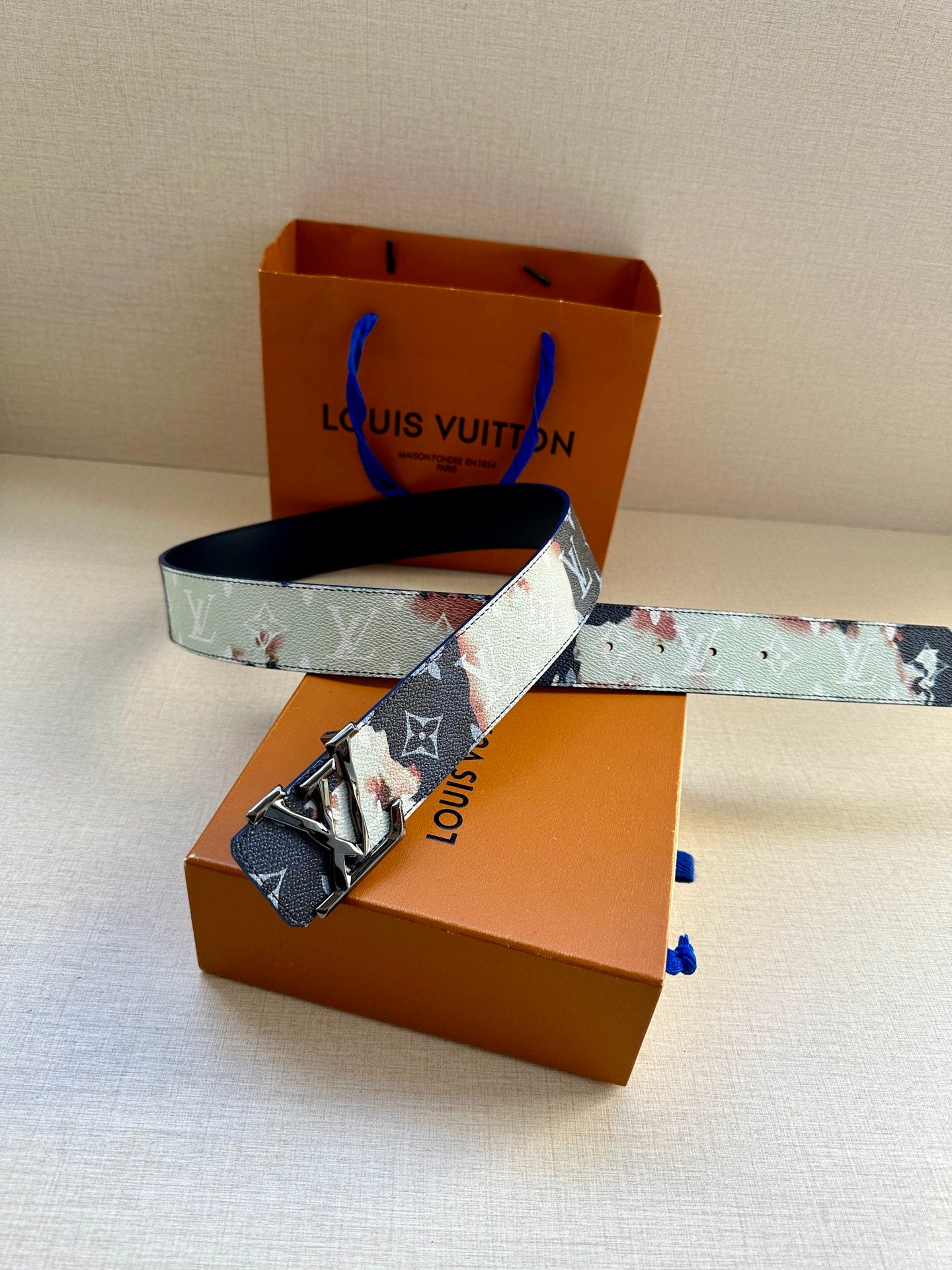 Louis Vuitton belt on display with blue-and-light monogram strap and silver buckle