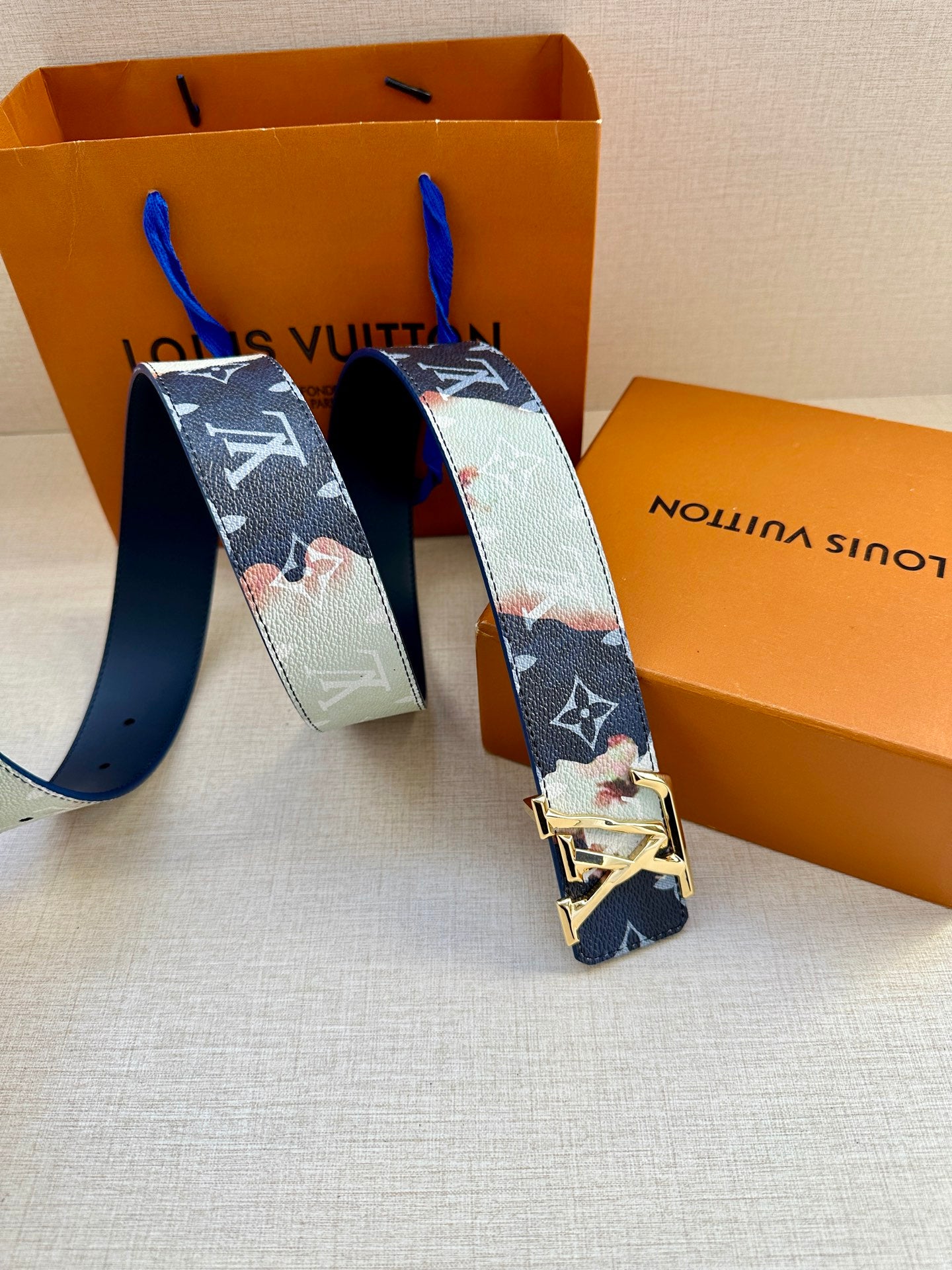 Louis Vuitton belt with blue-and-light monogram strap and gold-toned buckle, side-by-side ends