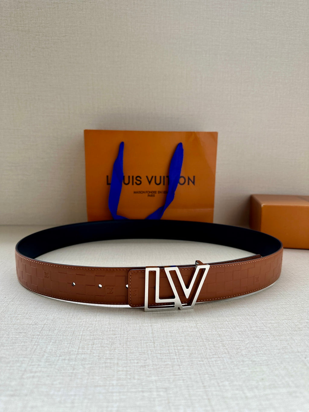 Brown leather belt with monogram-style pattern and large LV buckle