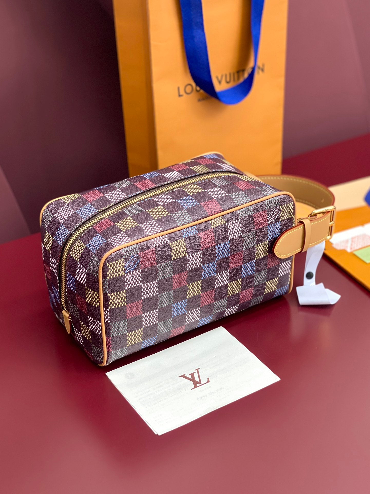 Louis Vuitton check-pattern small bag with zip closure and tan side tab