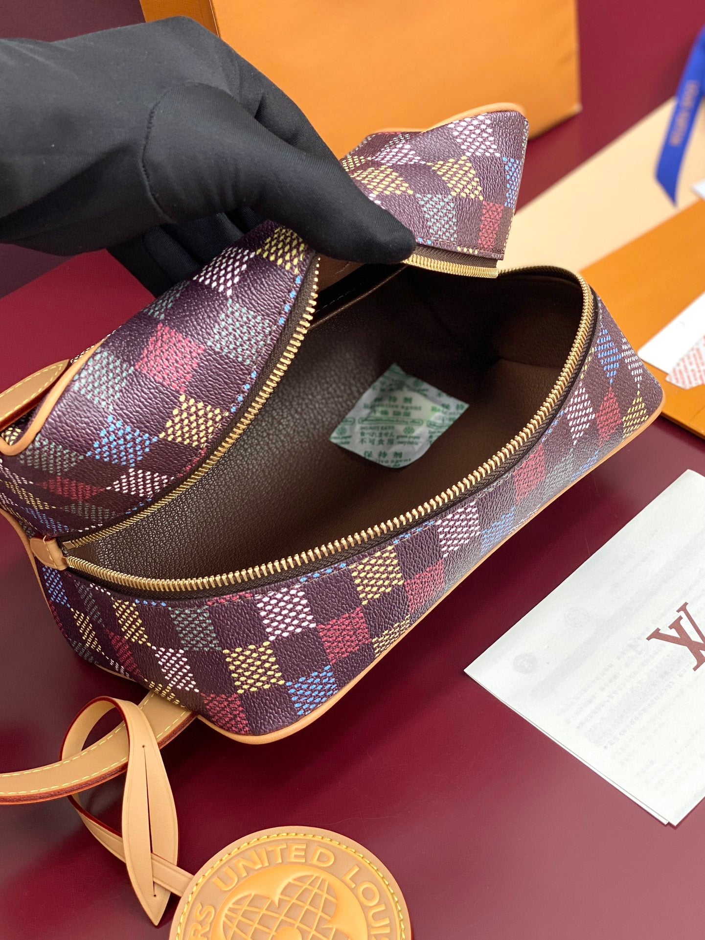 Louis Vuitton check small bag with open zipper, brown interior and charm tag