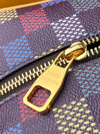 Small bag with textured dark purple fabric, multicolor geometric print, gold zipper pull.