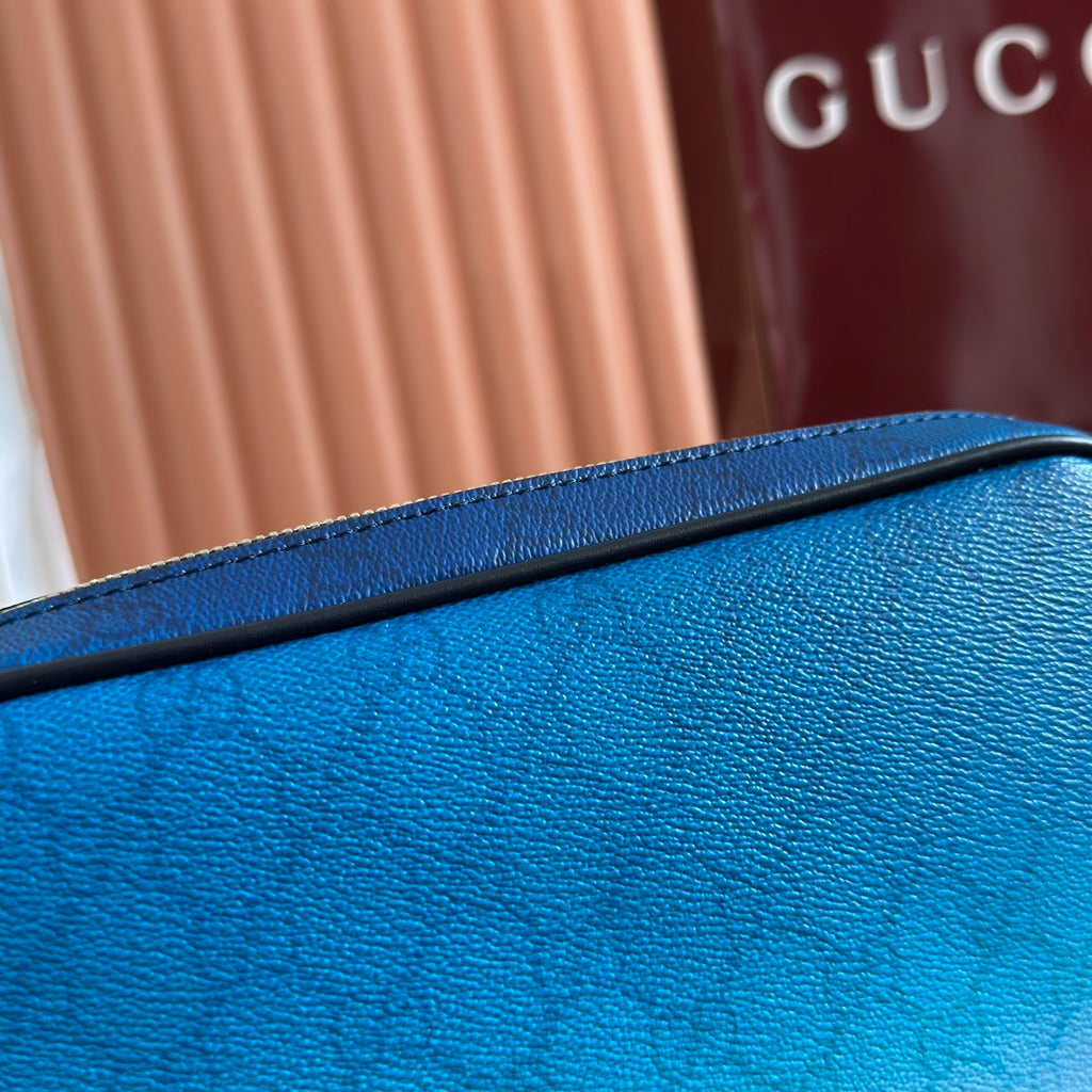 Gucci bag close-up of blue textured leather with black edge trim and zipper piping