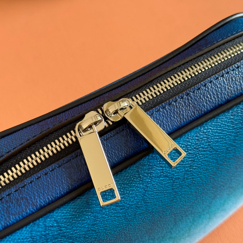 Gucci bag zipper pull hardware: gold-tone rings and rectangle tabs on blue leather