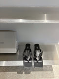 Balenciaga black leather sandals, square toe, buckle straps, flat on display shelf