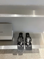 Balenciaga black leather sandals, square toe, buckle straps, flat on display shelf