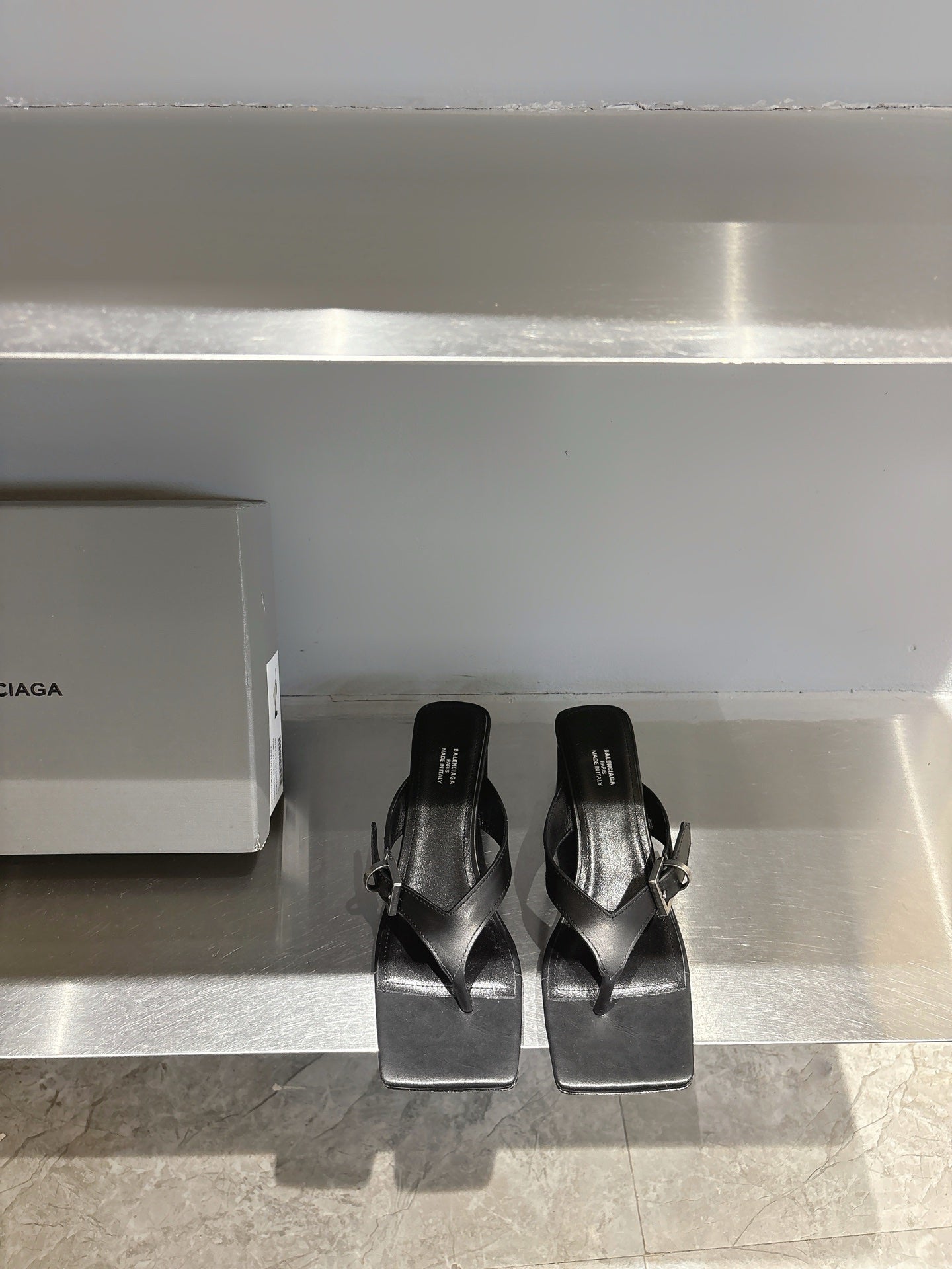 Balenciaga black leather sandals, square toe, buckle straps, flat on display shelf