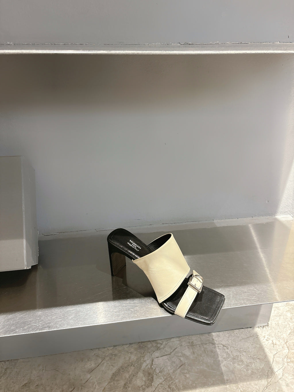 Balenciaga cream slide sandal on black block heel, front strap with buckle