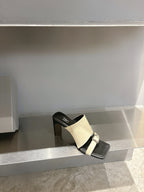 Balenciaga cream slide sandal on black block heel, front strap with buckle