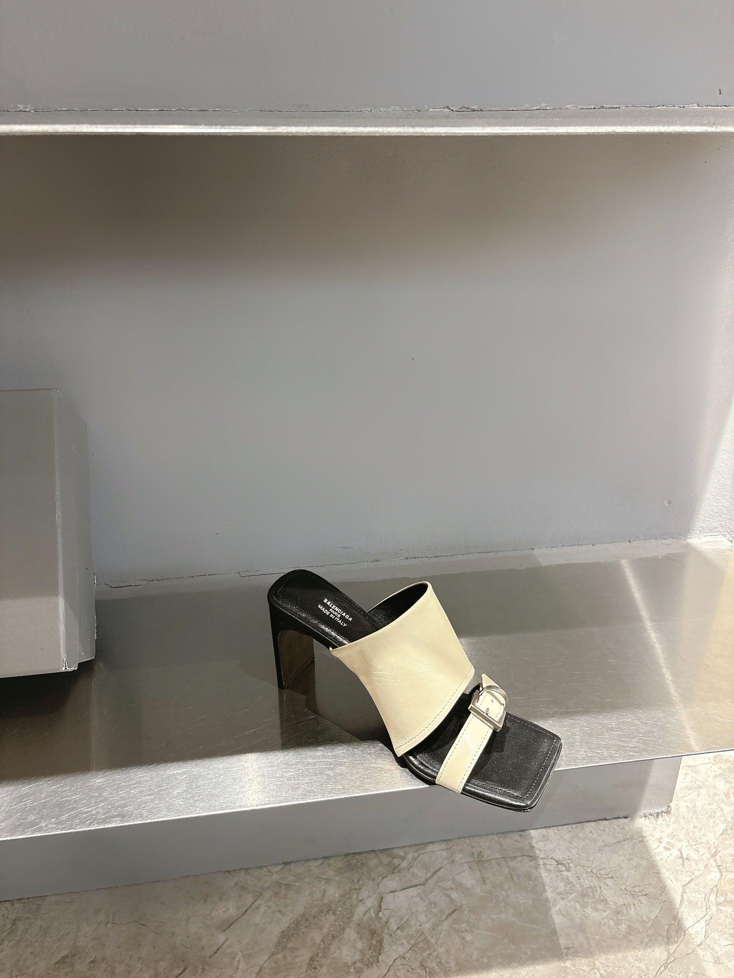 Balenciaga cream slide sandal on black block heel, front strap with buckle
