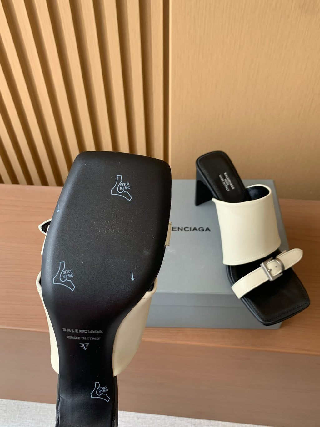 Balenciaga sandals with black upper and cream strap, logo prints on heel side