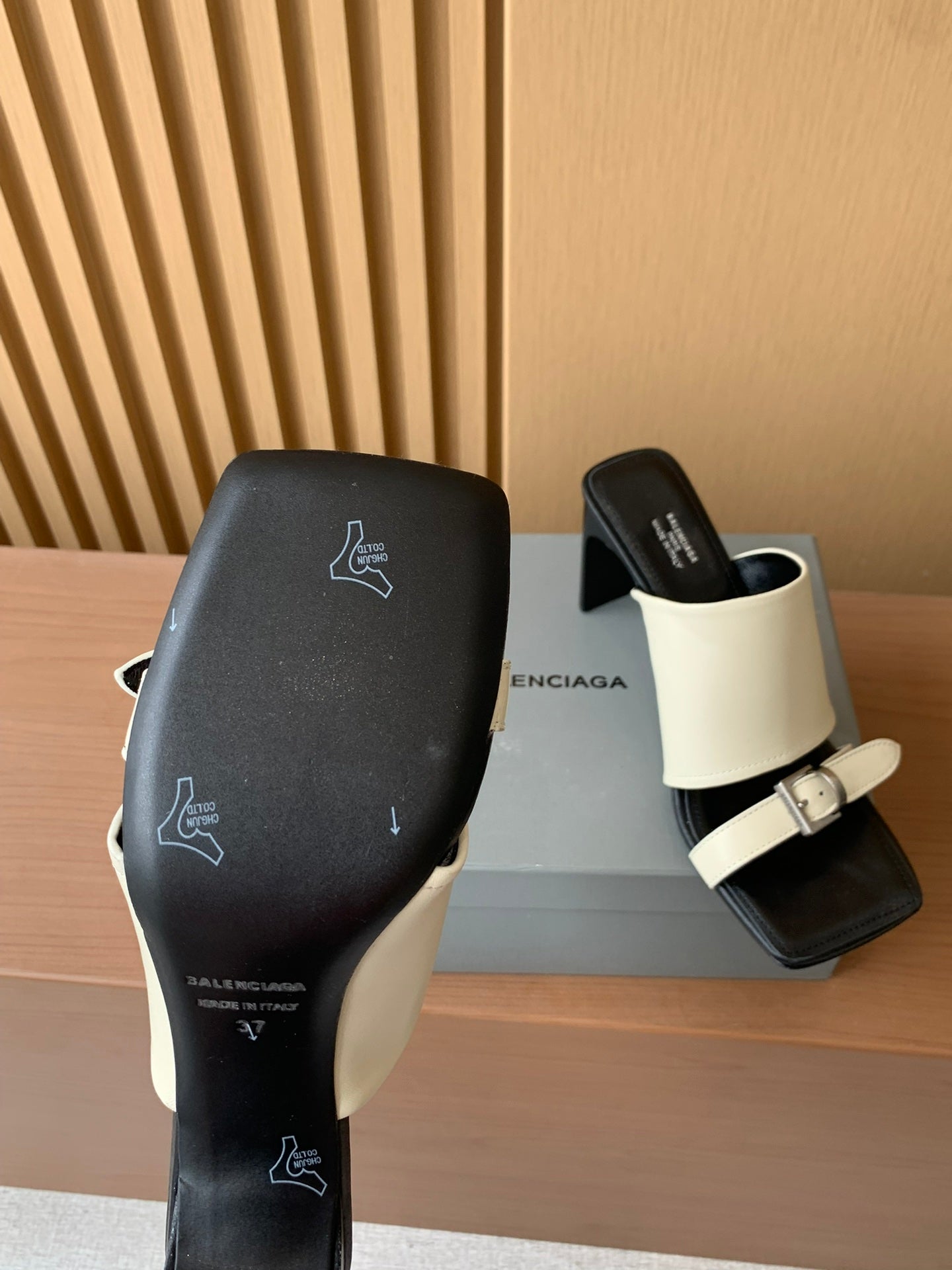 Balenciaga sandals with black upper and cream strap, logo prints on heel side