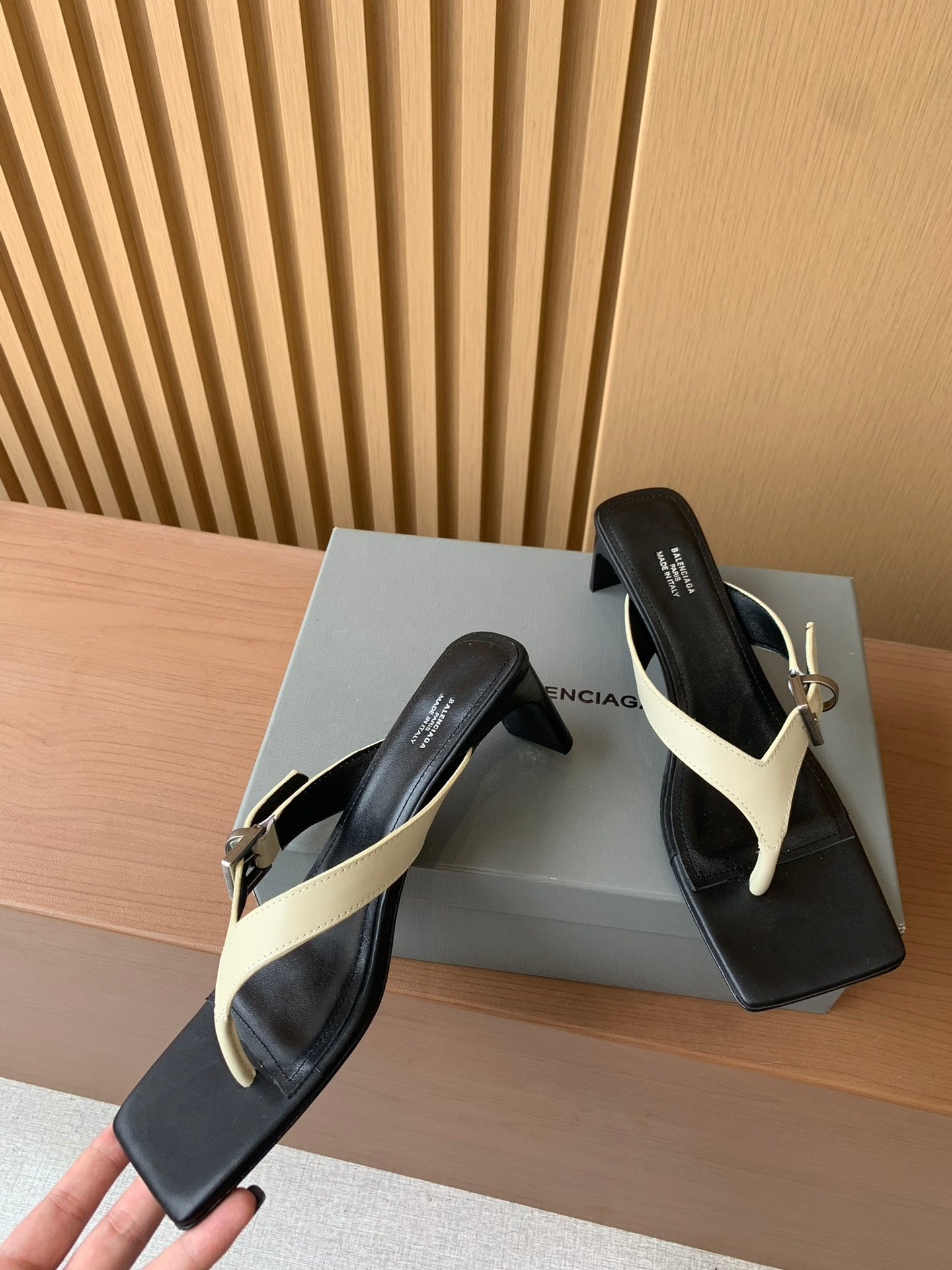 Balenciaga thong sandals pair, black uppers with cream V-strap and gold buckle