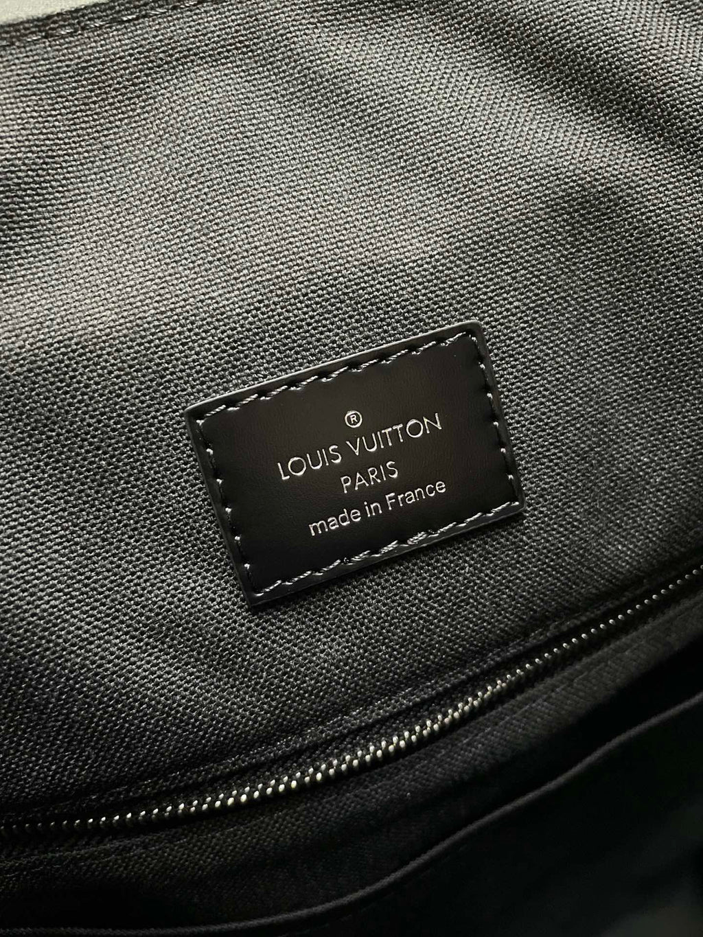 Louis Vuitton Paris made in France interior label on dark textured fabric