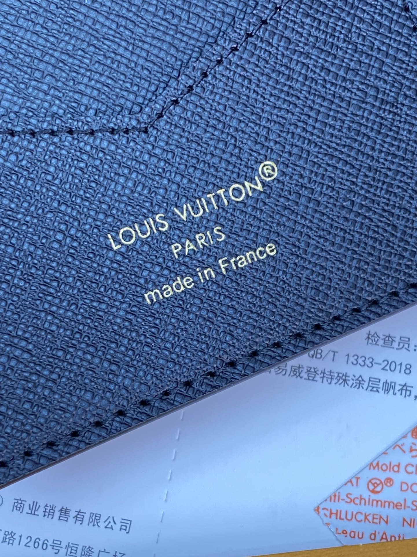 Small bag close-up of navy fabric with "Louis Vuitton" and "made in France".