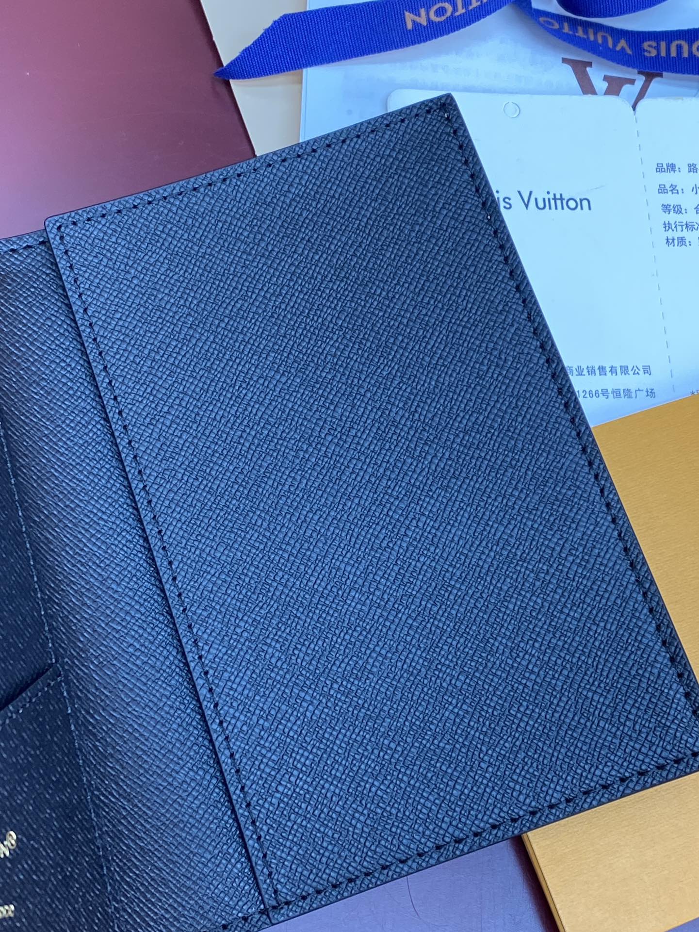 Small bag with textured navy exterior and stitched edges, close-up view.