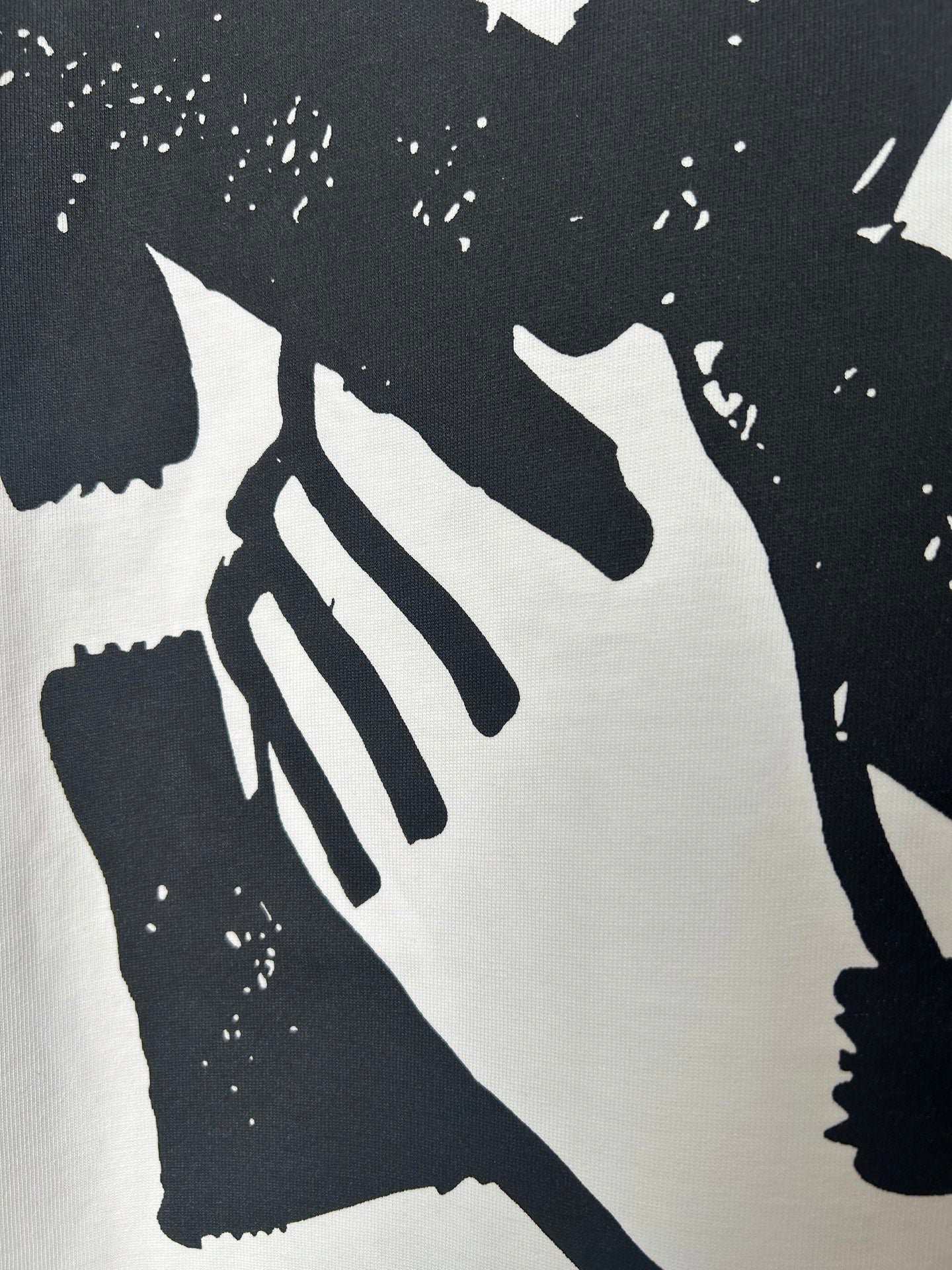 Off-white T-shirt close-up of large black graphic with striped details