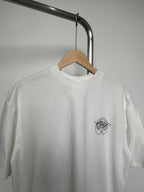 Off-white T-shirt close-up of neckline and small black logo at left chest