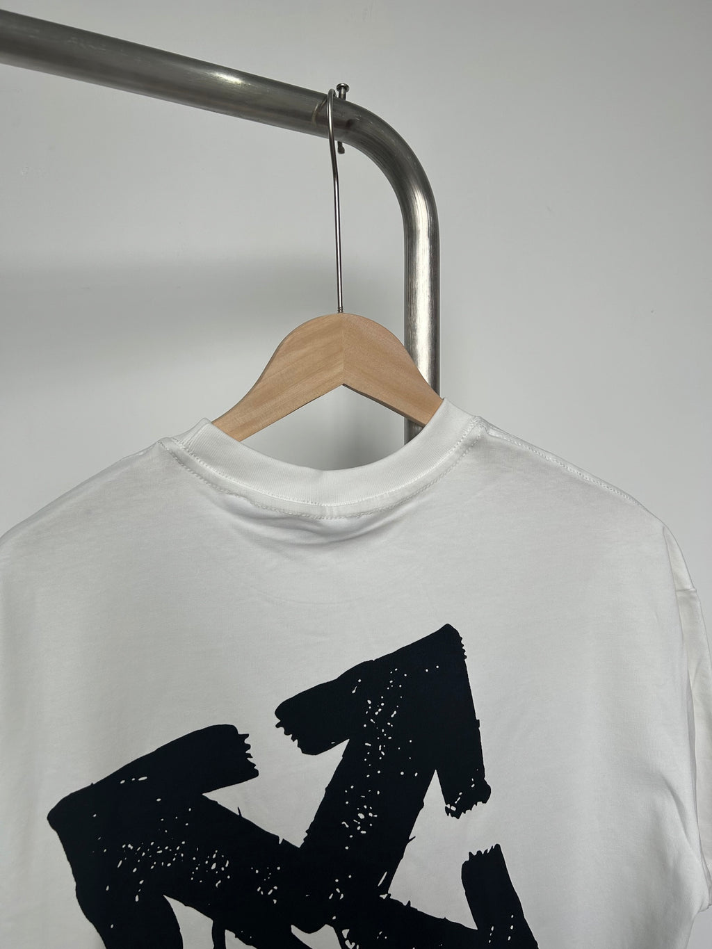 Off-white T-shirt showing large black graphic and crew neck