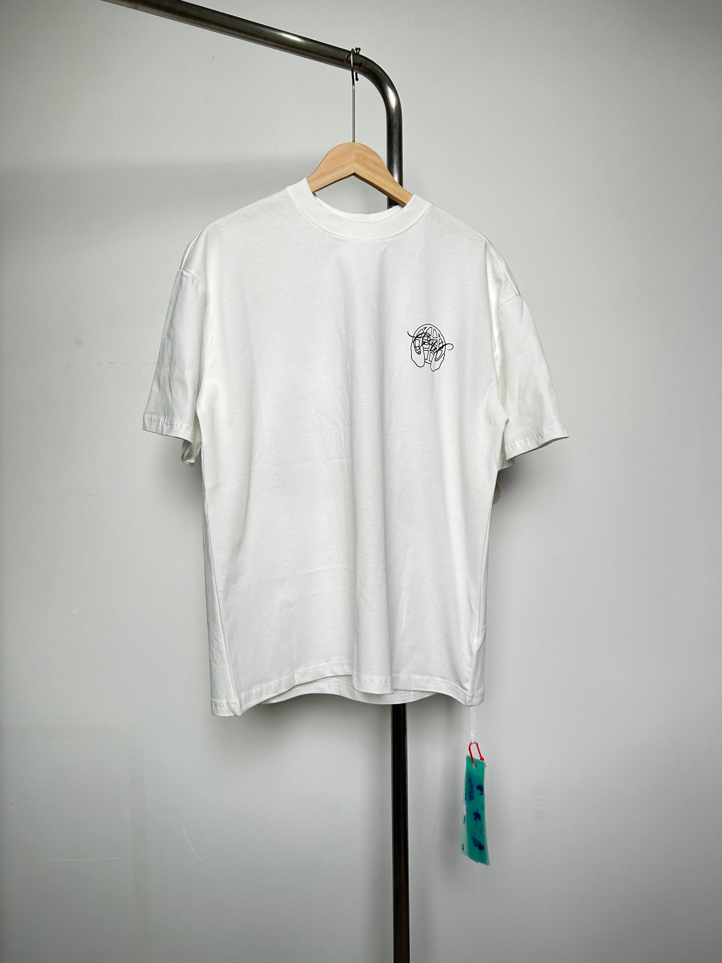 Off-white T-shirt with small black graphic logo at left chest