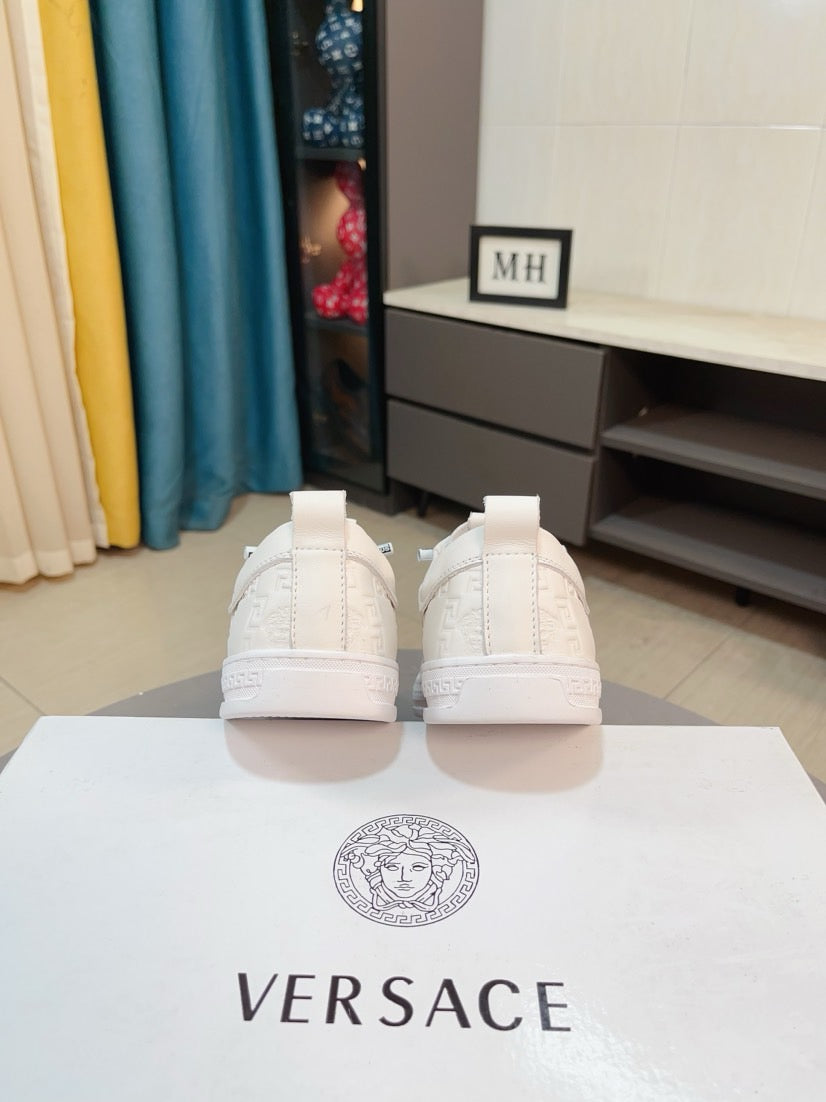 Back view of white luxury sneakers, lace-up with heel tabs and smooth rubber soles.