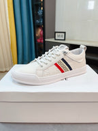 White luxury low-top sneaker with lace-up front and Greek key side stripe detail.