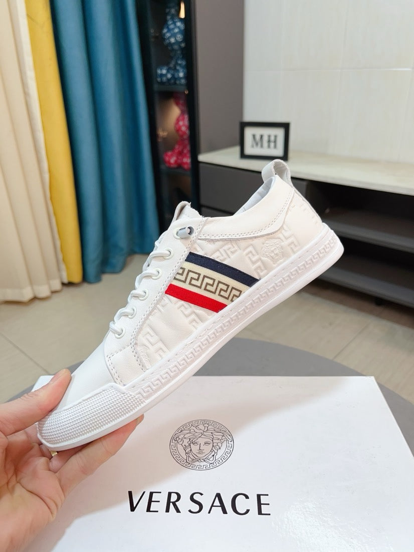 White luxury sneaker with lace-up, Greek key side stripe and textured, grippy sole.