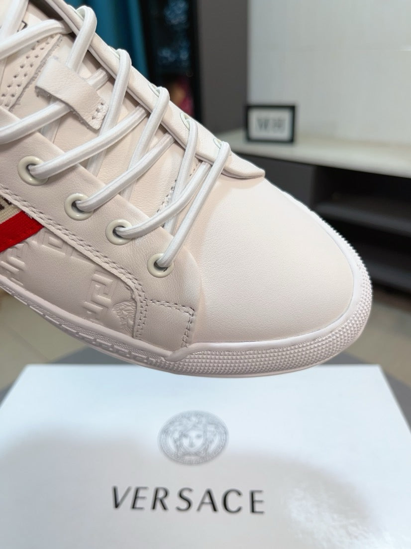 Close-up of white luxury sneaker toe, lace-up with embossed panel and textured edge.