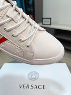 Close-up of white luxury sneaker toe, lace-up with embossed panel and textured edge.