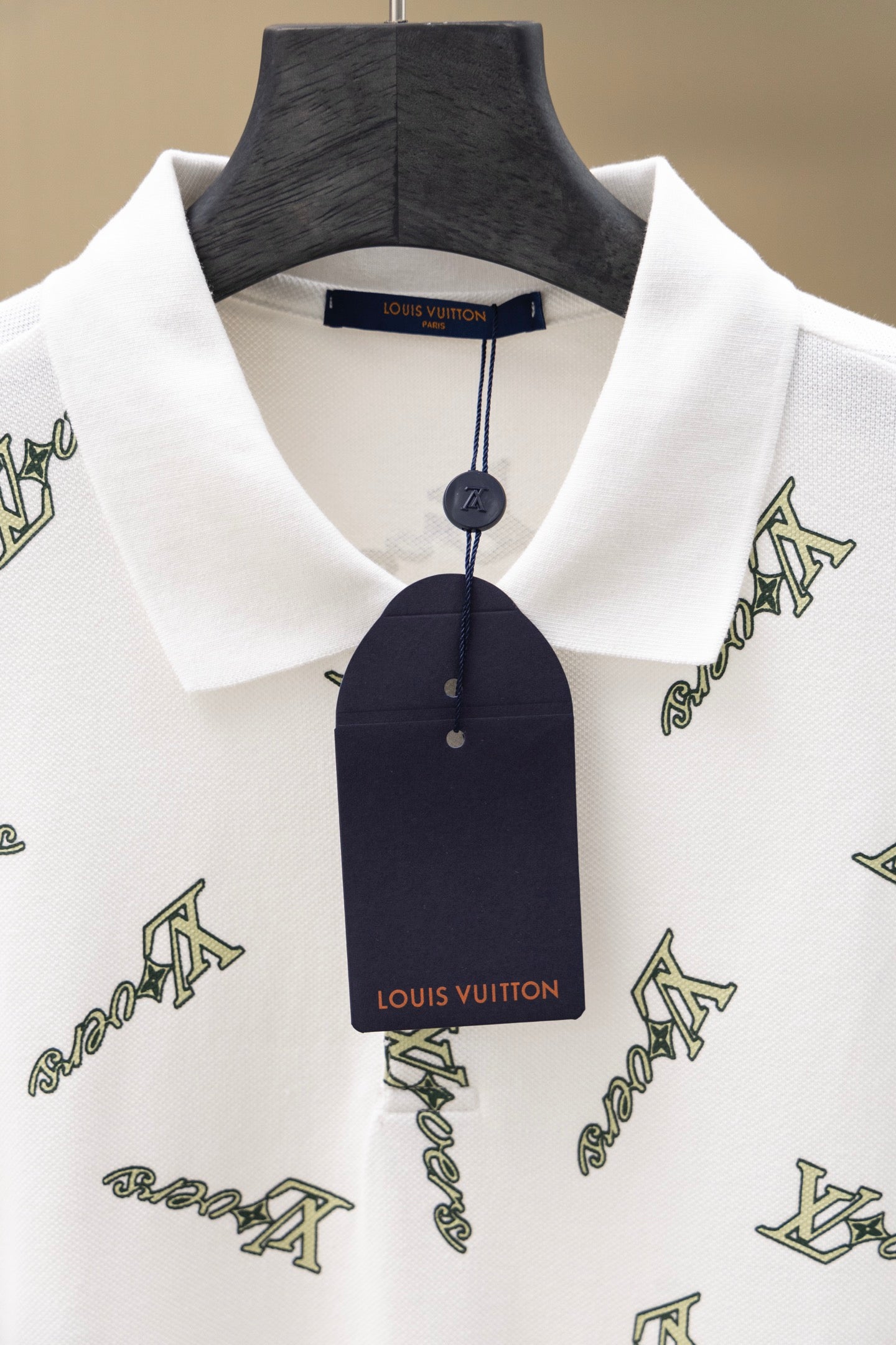 White polo shirt collar with hang tag on neckline and Louis Vuitton-style logo print
